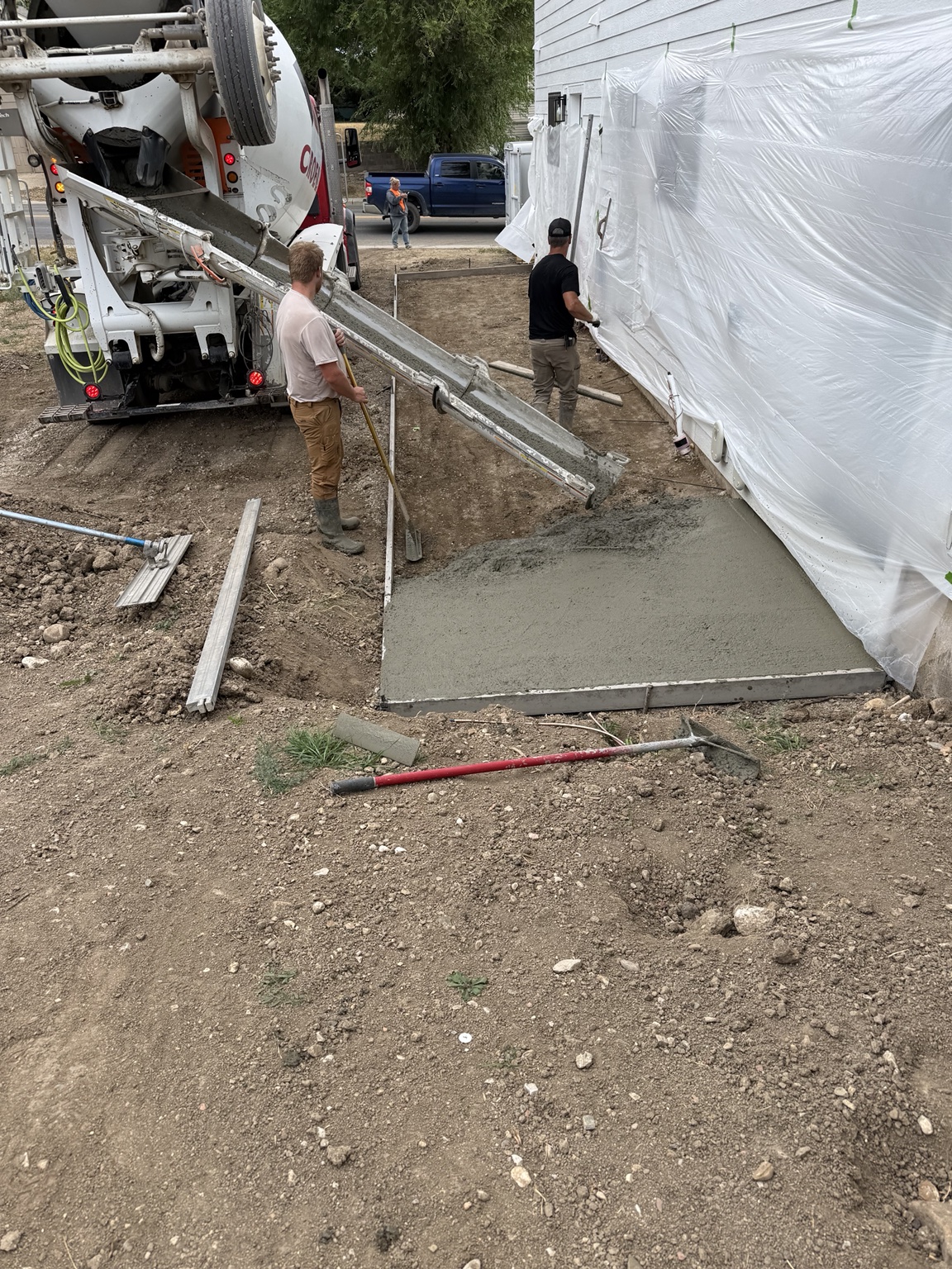 Concrete placement beside a protected residential exterior.